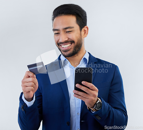 Image of Credit card, phone and smile with man in studio for online shopping, fintech and investment. Banking, ecommerce and app with male on gray background for customer experience, payment and retail