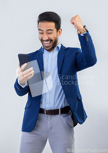 Image of Winner, yes and phone with man in studio for good news, success and bonus. Pride, excited and celebration with male and cheering isolated on gray background for achievement, pride and job promotion