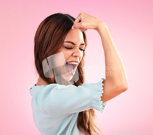 Image of Strong, proud and female flexing in a studio for feminism, women empowerment and body positivity. Happiness, excited and young woman model posing to show her arm strength isolated by pink background.