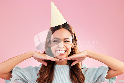 Image of Birthday woman, face portrait and smile for happy celebration event, congratulations or celebrate happiness. Studio posing, party hat and headshot female, person or young model on pink background