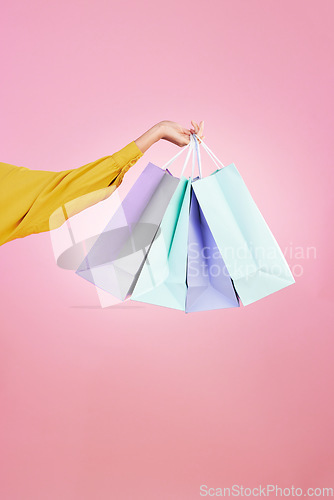 Image of Shopping bag, studio and hands of woman, person or female with retail sales product, discount deal or mall store present. Market choice purchase, luxury designer gift and customer on pink background