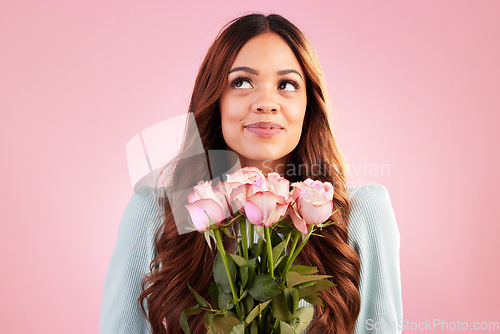 Image of Happy, thinking and female with roses in a studio for valentines day, romance or anniversary. Happiness, smile and young woman model from Mexico with a bouquet of flowers isolated by pink background.