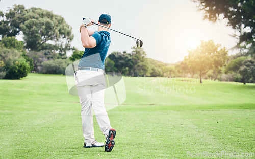 Image of Golf, back and hobby with a sports man swinging a club on a field or course for recreation and fun. Golfing, grass and stroke training with a male golfer playing a game on a green during summer