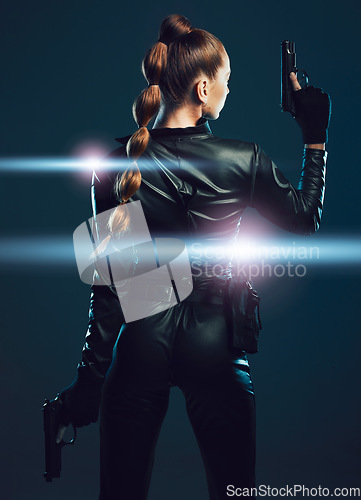 Image of Warrior, woman and gun to fight in studio for action or danger on dark background. Strong female model, assassin or agent in scifi futuristic cosplay costume with weapon as ninja or vigilante mission