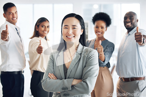 Image of Asian woman, leadership and arms crossed, team and thumbs up, lead and professional mindset with collaboration. Diversity, teamwork and agreement, corporate group in workplace and smile in portrait