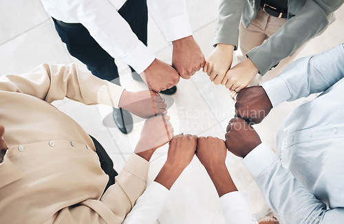 Image of Mission, circle or business people fist bump for partnership or motivation in office meeting together. Diversity, top view or employees with teamwork, strategy or group support for project goal