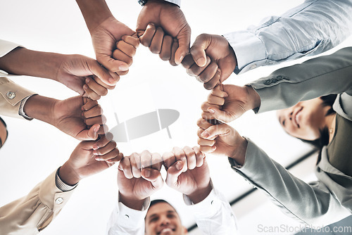 Image of Team building, circle or business people hands in fist for motivation in office meeting together. Diversity, low angle or happy employees with mission, strategy or group support for project planning