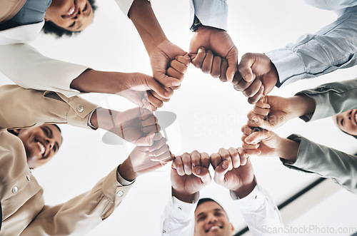 Image of Team building, circle or happy business people fist bump for motivation in office meeting together. Diversity, low angle or employees with mission, strategy or group support for project goal