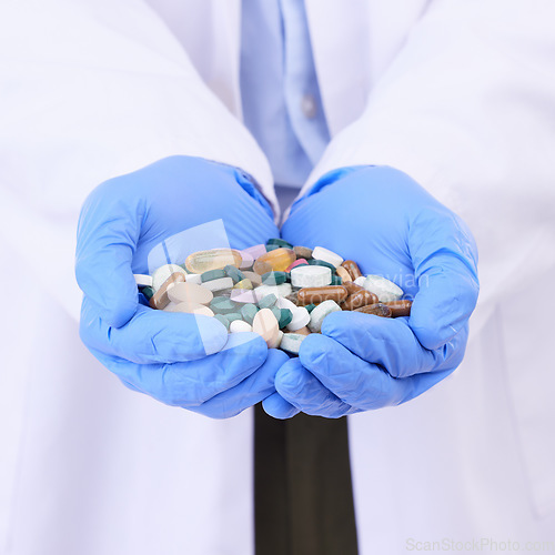 Image of Hands, healthcare or pills with a doctor in clinic holding medication for the treatment of disease. Medical, hospital or tablets with a variety of medicine in the hand of a professional health worker