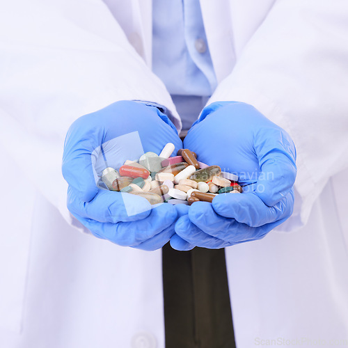 Image of Hands, medical or pills with a doctor in clinic holding medication for the treatment of disease. Healthcare, hospital or tablets with a variety of medicine in the hand of a professional health worker