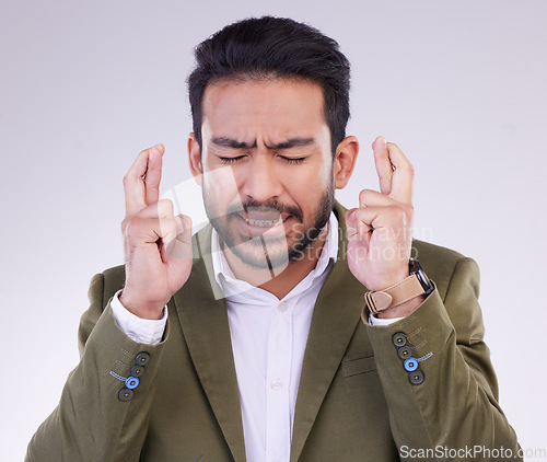 Image of Success, business and Asian man with fingers crossed, hope and promotion against a studio background. Japanese male employee, entrepreneur and guy with luck, opportunity and hand emoji sign for prize