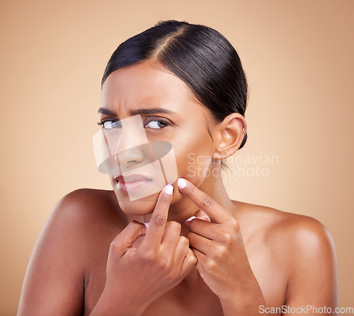 Image of Indian woman, pimple and skincare in studio for treatment, cosmetics and worried by background. Model girl, young asian and upset face for self care with cosmetic wellness, skin acne and aesthetic