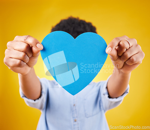 Image of Paper, heart and cover with woman in studio for romance, positive and emotion. Happiness, love shape and giving with female isolated on yellow background for date, feelings and affectionate