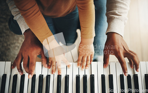 Image of Hands, parent and kid learning piano as development of skills together and bonding while making music in a home. Closeup, musical and child playing a song on an instrument and father teaching