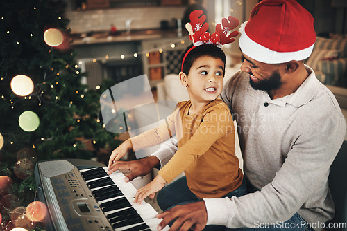 Image of Happy family, father and kid at piano for christmas celebration, song and xmas at home. Parent, boy child and teaching keyboard instrument, festive music or celebrate holiday spirit together in house