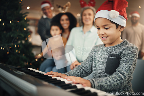 Image of Boy child, music keyboard and christmas in family home with smile, playing and creative with happiness. Kid, young musician and parents by piano for holiday cheer, bond and song for pride in house