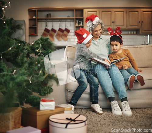 Image of Christmas, photo album or kids with a senior woman and children looking at photographs during festive season. Family, love or celebration with a grandmother and grandchildren holding a picture book