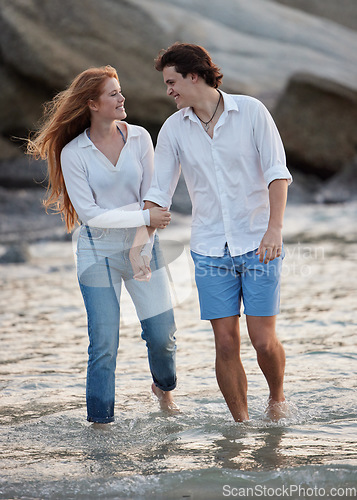 Image of Couple walking in ocean, holding hands and travel with love and commitment in relationship with adventure at beach. Trust, partnership and care with people outdoor, romance and happiness together