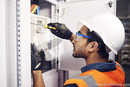 Image of Man, electricity and screwdriver of maintenance box in control room, engineering or machine mechanic. Male electrician, screw tool and power installation of industrial generator, technician or repair