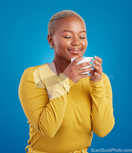 Image of Coffee, aroma and a black woman on a blue background in studio smelling the scent for her mug. Relax, drink and easy with an attractive young female enjoying a fresh cup of caffeine during a break