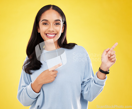 Image of Yellow background, point and portrait of woman with smile for advertising, promotion and announcement. Mockup space, studio and isolated happy girl with hand gesture for information, discount or news