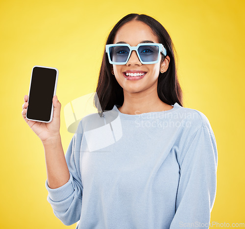 Image of Phone, fashion and portrait of woman with sunglasses in yellow studio for social media, website and internet. Communication, mockup space and happy girl on smartphone for chat, promotion and network