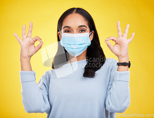 Image of Covid, okay sign and portrait of woman in studio for positive, illness and approval. Protection, prevention and disease with female isolated on yellow background for medical, healthcare and pandemic