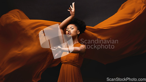 Image of Black woman, art and fashion, fabric on dark background with dance and aesthetic movement. Flowing silk, fantasy and artistic portrait of serious African model in creative designer dress in studio.