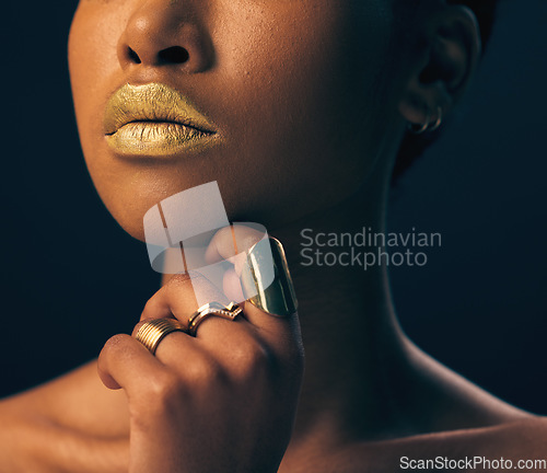 Image of Closeup, jewelry and black woman with foundation, makeup and grooming against dark studio background. Zoom, female and lady with gold lipstick, rings and cosmetics for skincare, aesthetic and luxury