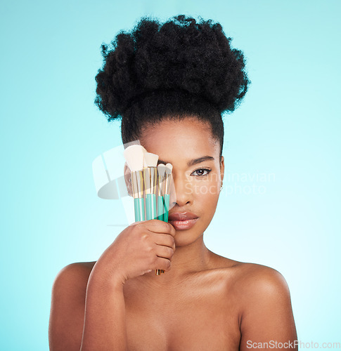 Image of Portrait, brushes and black woman with skincare, cosmetics and treatment against blue studio background. Face, African American female and lady with cosmetic tools, grooming and confidence with glow