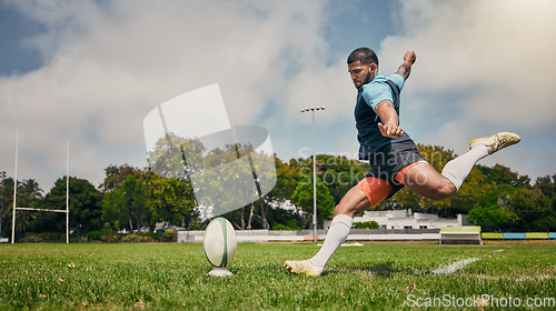 Image of Rugby, action and man kicking ball to score goal on field at game, match or practice workout. Sports, fitness and motion, player running to kick at poles on grass with energy and skill in team sport.