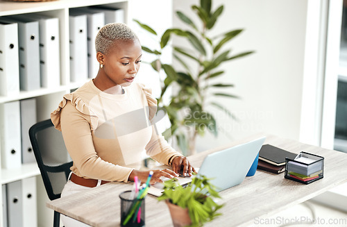 Image of Serious black woman, laptop and business at desk, online research and planning strategy. Young female worker typing on computer technology for administration, digital management and project update