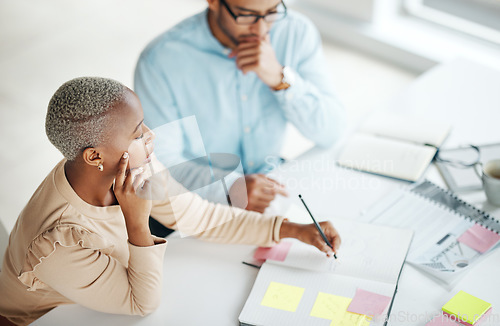 Image of Collaboration, strategy overhead and a business black woman at work with a man colleague in an office. Teamwork, planning and documents with professional people brainstorm thinking while working