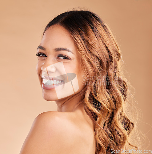 Image of Beauty, woman and hair care portrait with a smile for growth or shine with strong texture on brown background. Aesthetic female happy in studio with glow and healthy curls and salon color protect
