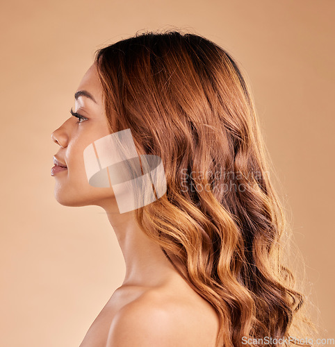 Image of Woman, beauty and hair care profile with healthy growth or shine and strong texture on brown background. Aesthetic female in studio with glow, long curls and color for haircare and skincare wellness