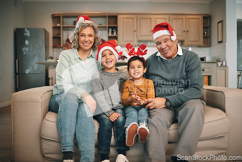 Image of Portrait of grandparents with children in christmas hats relaxing on sofa in the living room. Happy, love and elderly couple sitting with kids with festive, holiday or xmas accessories at family home