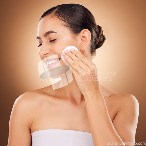 Image of Skincare, cotton pad and woman face cleaning of a young person with happiness in a studio. Happy smile and dermatology treatment of a female with cosmetics, spa and cosmetology luxury facial