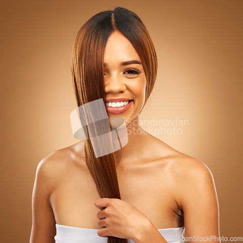 Image of Haircare, smile and portrait of woman in studio holding strong hair in hand with texture and shine. Happy model, mockup and beauty, healthy straight hairstyle with keratin product on brown background