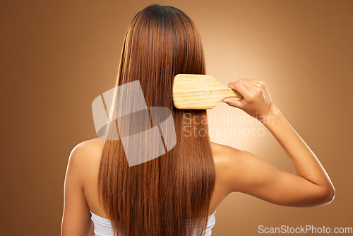 Image of Back of hair, brush and woman in studio for beauty, wellness and keratin treatment on brown background. Hairdresser mockup, salon and girl brushing hairstyle for growth, haircare texture or cosmetics
