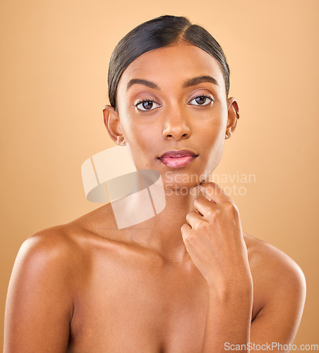 Image of Serious, beauty and portrait of a woman with makeup isolated on a studio background. Wellness, lifestyle and an Indian model with cosmetics promotion, feminine and looking elegant on a backdrop