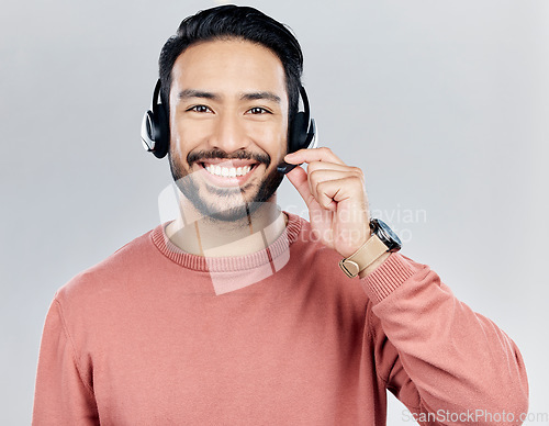 Image of Asian man, portrait smile and headphones with mic for call center or online customer service against a white studio background. Happy male consultant with headset smiling for wireless communication