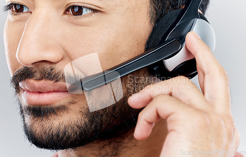 Image of Man, face and headset for call center, telemarketing or online customer service against gray studio background. Closeup of male consultant with headphones and mic for wireless communication or advice
