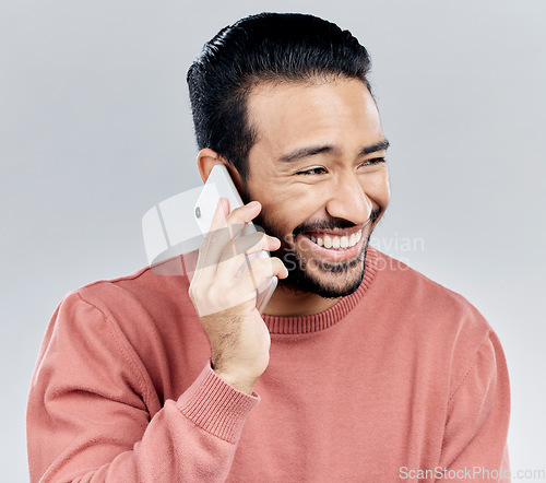 Image of Asian man, phone call and laughing for funny conversation, discussion or joke against a white studio background. Happy male laugh and talking on mobile smartphone for fun chat, communication or meme