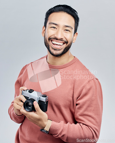 Image of Portrait, studio and man with camera, tourist and photographer against a grey background. Face, male creative and guy with smile, photography and artist with happiness, memories and capture moment