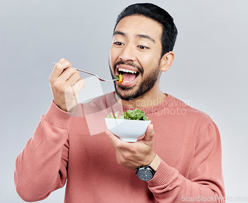 Image of Man, salad and eating healthy food in studio for health or wellness motivation for vegetables. Asian male vegetable bowl for nutrition, diet and benefits for digestion or lose weight white background