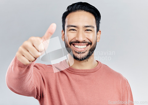 Image of Portrait, great and Asian man with thumbs up, vote and happiness against a studio background. Face, Japanese male and guy with gesture for well done, promotion and agreement with smile and approval