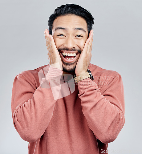 Image of Portrait, surprise and Asian man excited, wow and happiness against a grey studio background. Face, Japanese male and happy guy with victory, winning and smile with joy, good news and announcement