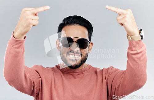 Image of Portrait, rude and man with anger, middle finger and frustrated against grey studio background. Face, male and guy with offensive hand gesture, aggressive and conflict with expression and disrespect