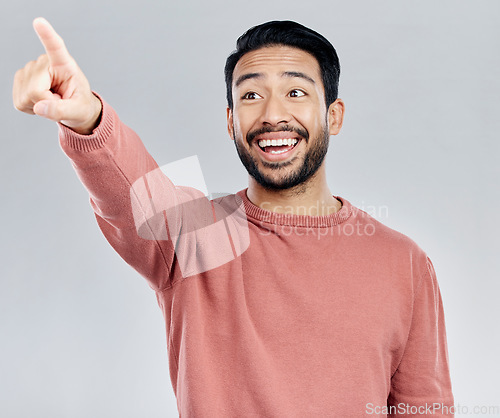 Image of Mockup, smile and Asian man pointing, promotion and product placement against grey studio background. Japan, male and happy guy with gesture for direction, space and brand development with happiness