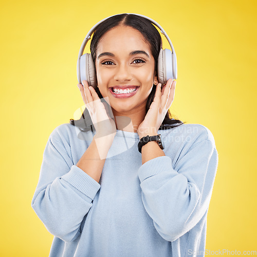 Image of Happy, music and headphones with portrait of woman in studio for streaming, online radio and audio. Smile, media and podcast with female on yellow background for technology, listening and connection